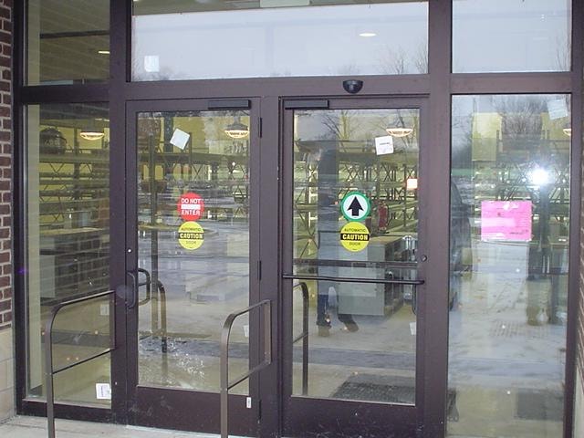 Automatic swing doors with caution signage brick building